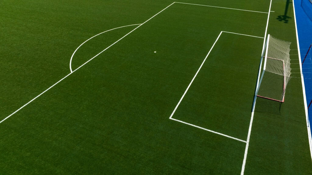 A close-up of a football field with goal and penalty spot