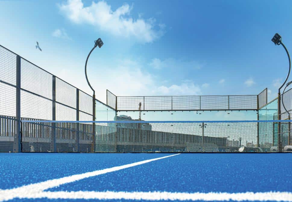 A padel racket and balls on a court