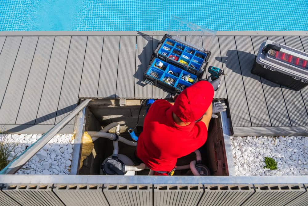A technician from a trusted pool maintenance company servicing a pool filtration system on-site