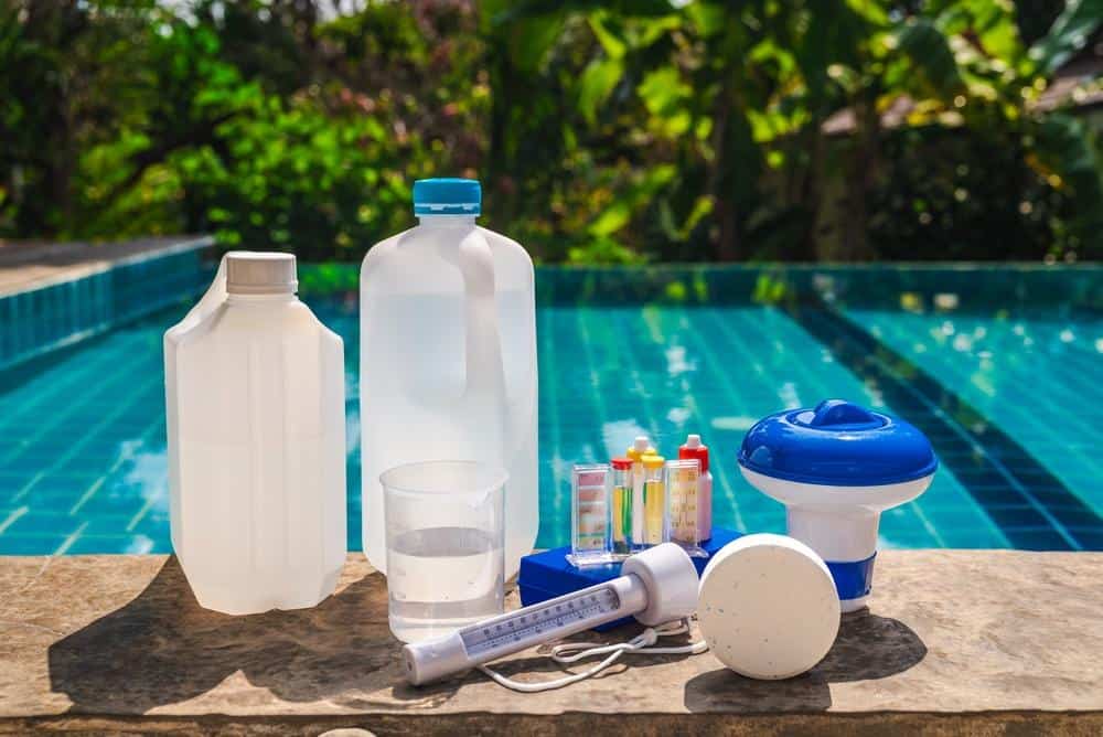Chemicals, pool stain remover, and equipment in a pool maintenance kit.