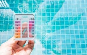 A staff is testing alkalinity level before deciding how to raise alkalinity in pool 